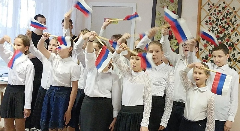 Дети поют и махают с флагами.